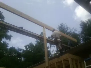 Carpenter setting a ridge beam over a new addition frame — Ice Dam Removal by Roofing Brothers in Beech Bottom