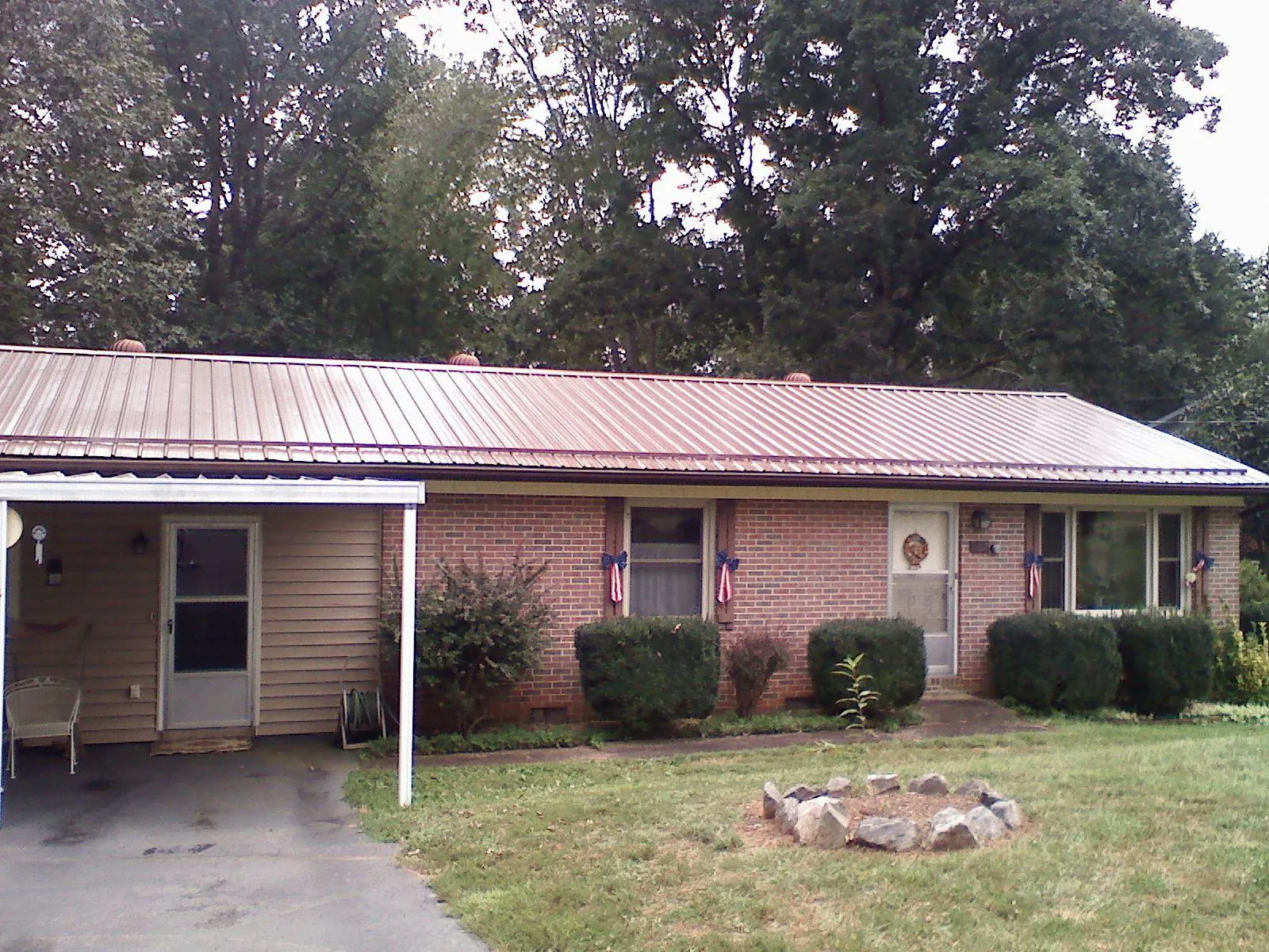 Bronze metal roof and carport on a brick ranch home — Roof Repair work by our crew in Beech Bottom